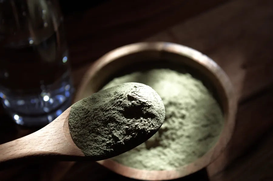A wooden scoop of Nourish greens powder