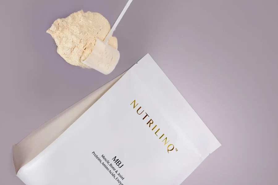 A scoop of MBJ protein powder beside the MBJ bag